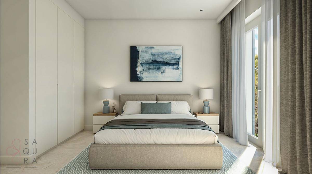 Helles Schlafzimmer mit Doppelbett, Einbauschränken und großem Fenster mit Vorhängen.