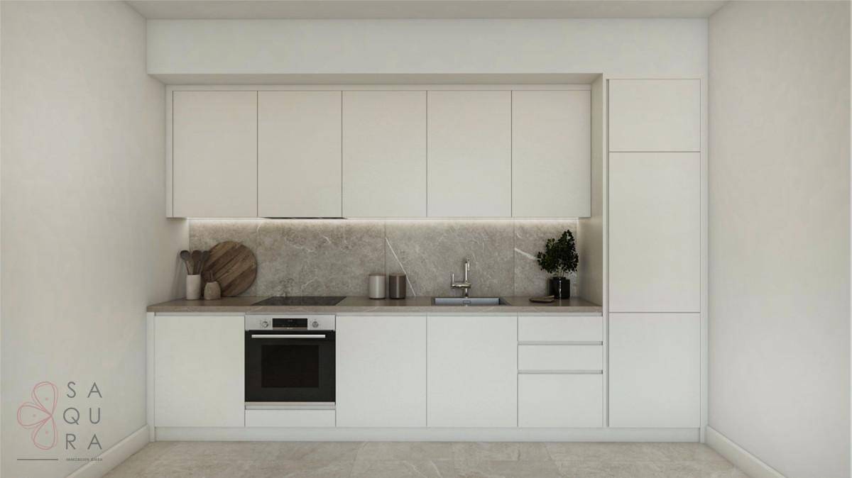 Moderne Einbauküche mit weißen Schränken, integrierten Geräten und heller Arbeitsplatte.