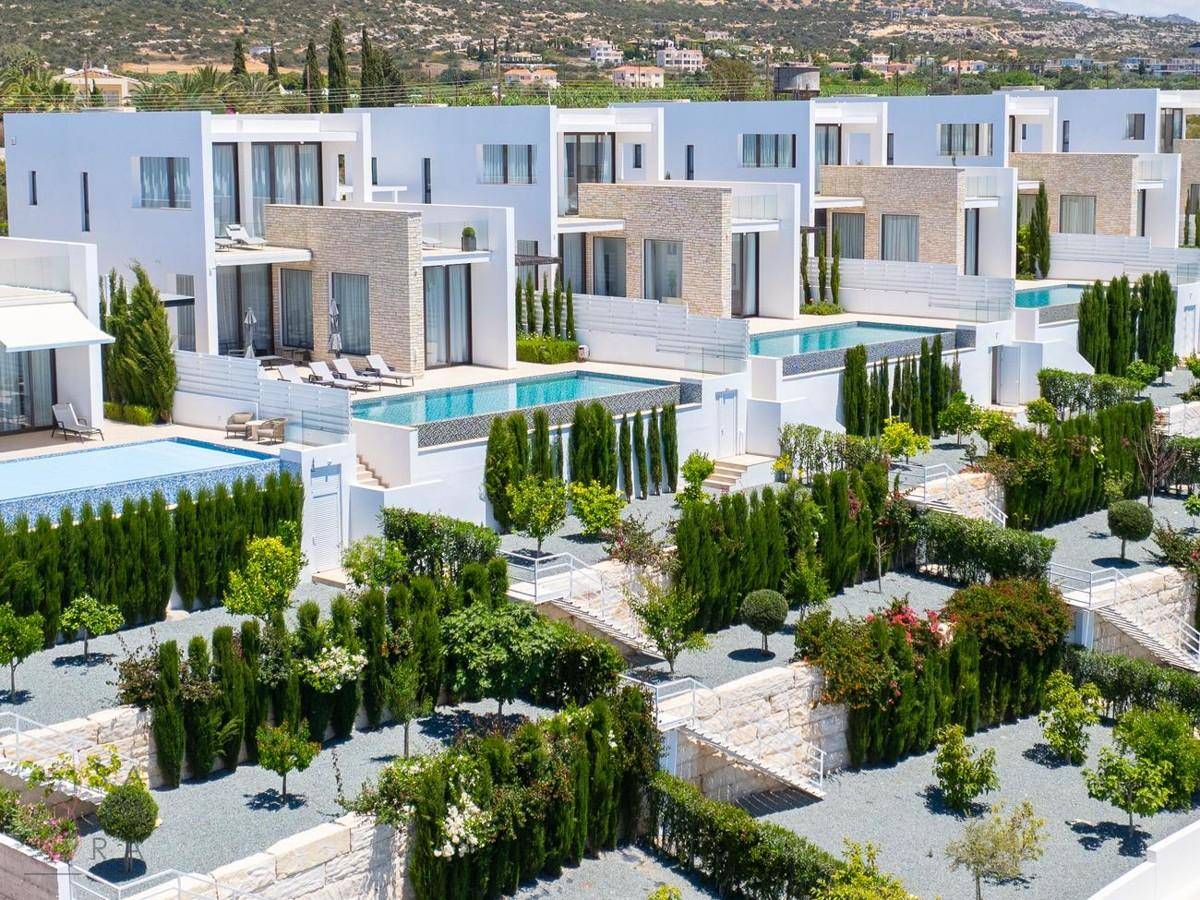 Reihen von modernen Villen mit privaten Pools und gepflegten Gärten in einer sonnigen Umgebung.