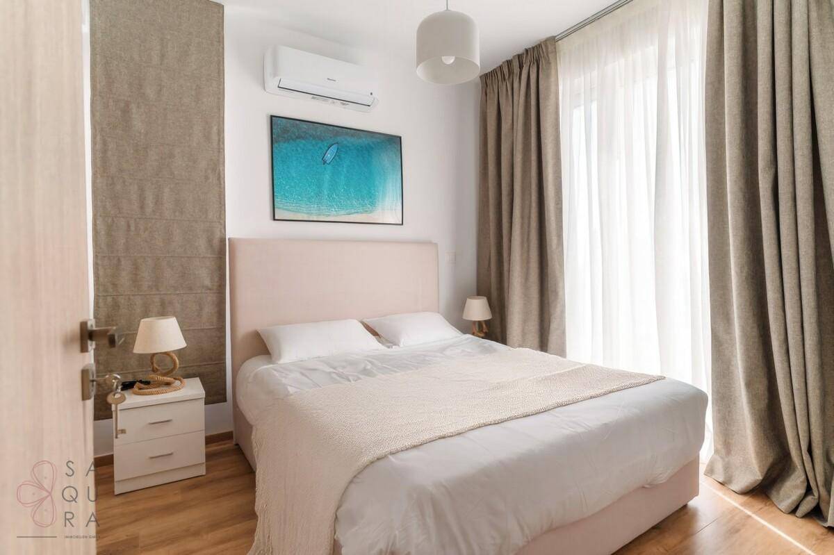 Modernes Schlafzimmer mit Doppelbett, Klimaanlage und großen Vorhängen für Privatsphäre.