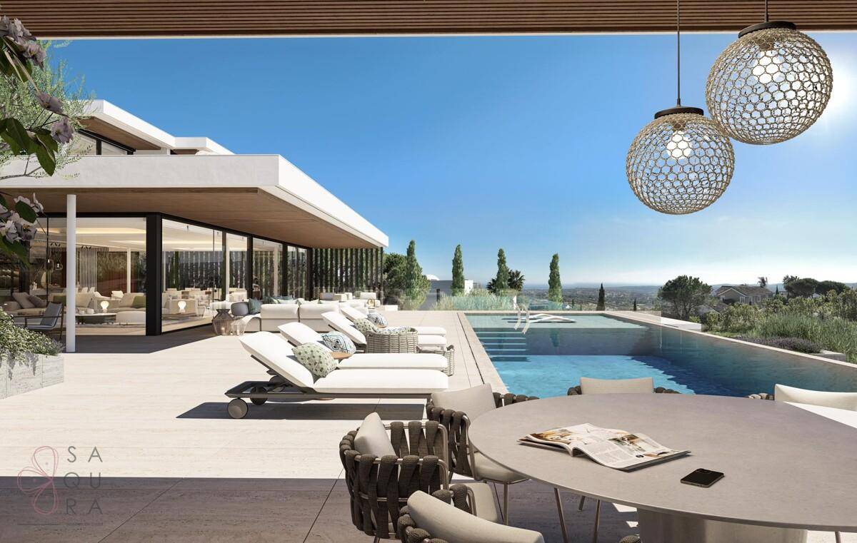 Geräumige Terrasse mit Esstisch, Sonnenliegen und weitem Blick über die Landschaft.