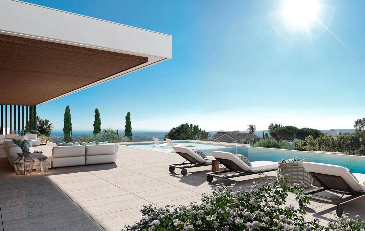 Sonniger Terrassenbereich mit Liegestühlen am Infinity-Pool und Panoramablick.