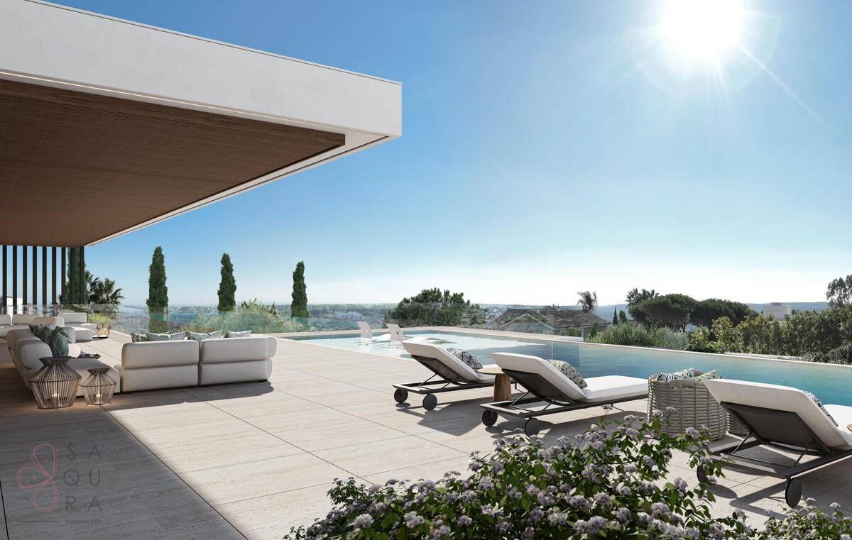 Sonniger Terrassenbereich mit Liegestühlen am Infinity-Pool und Panoramablick.