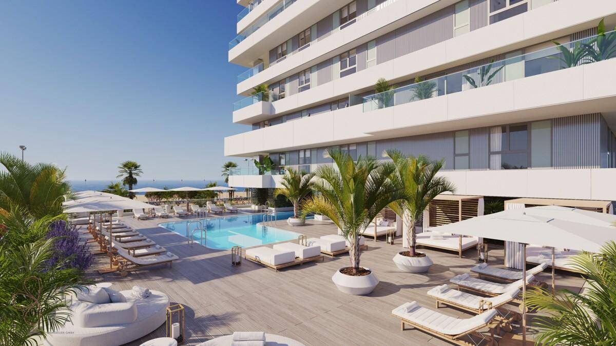 Luxuriöser Poolbereich mit Palmen, Liegestühlen und Meerblick neben dem modernen Gebäude.