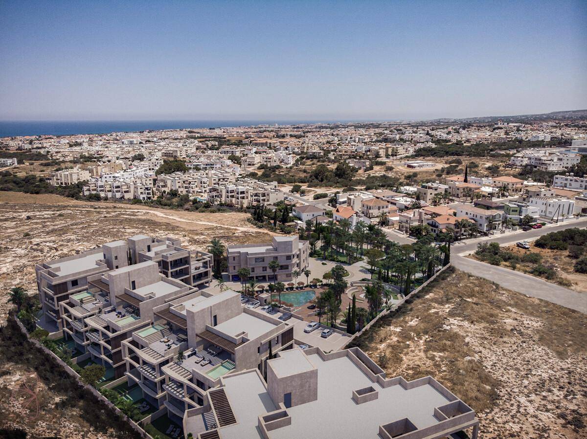 Weitläufige Luftaufnahme des modernen Wohnkomplexes mit umliegender Landschaft und Meerblick.