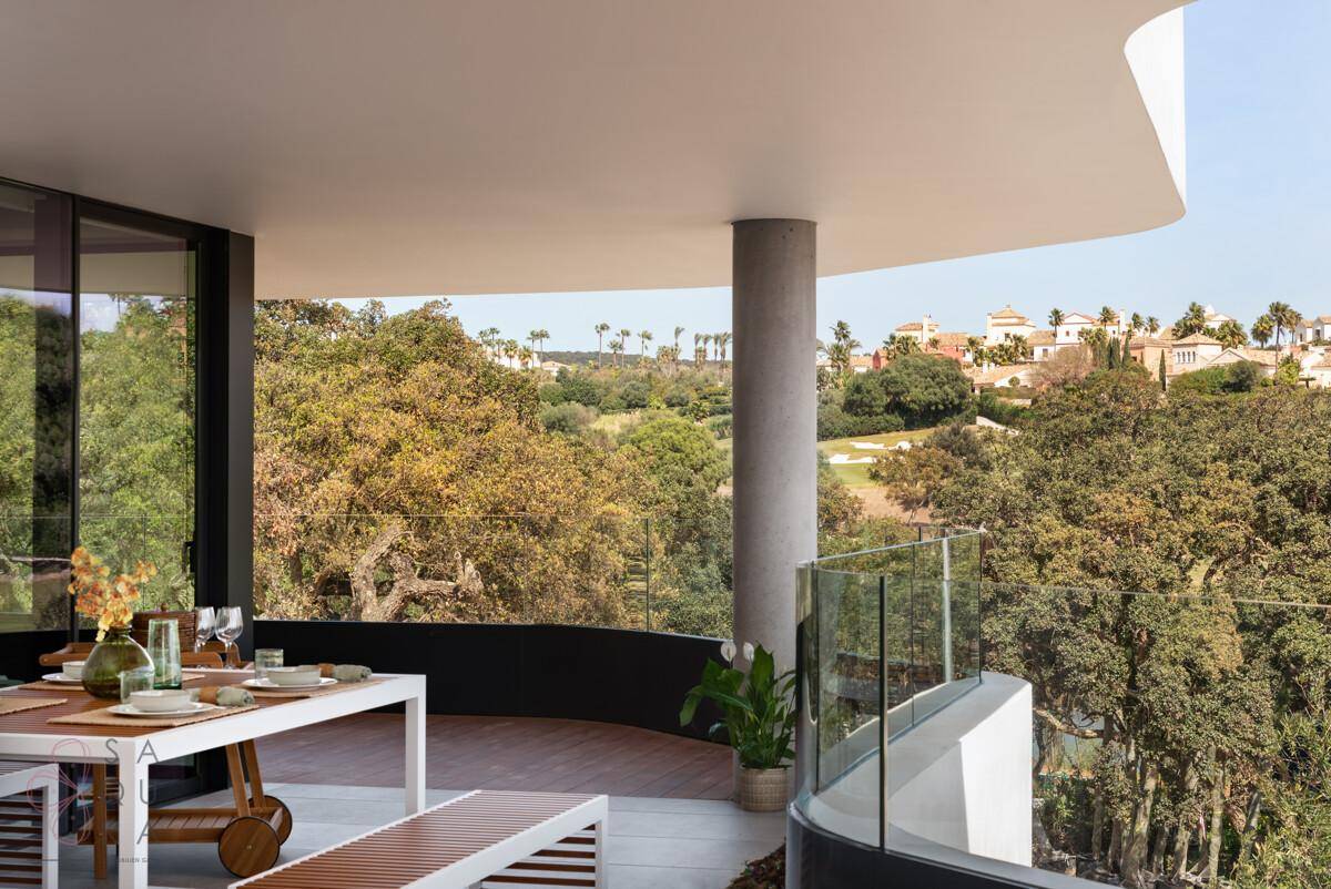 Große Terrasse mit Essbereich und Panoramablick auf die grüne Landschaft und das Meer in der Ferne.
