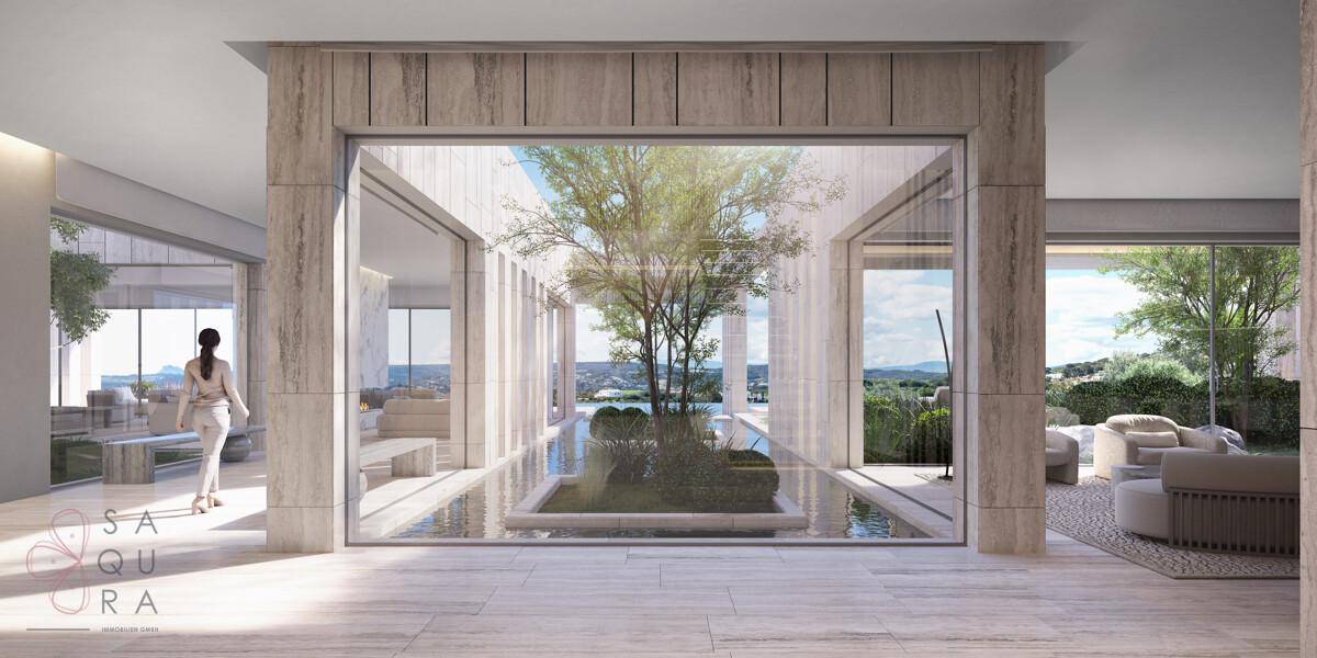 Heller Eingangsbereich mit großzügigen Glasfronten und einem begrünten Innenhof.