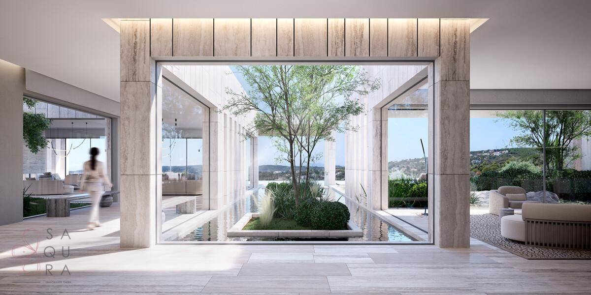 Heller Eingangsbereich mit großzügigen Glasfronten und einem begrünten Innenhof.