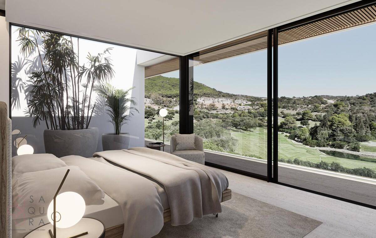 Helles Schlafzimmer mit großen Panoramafenstern und weitem Blick auf die grüne Landschaft.