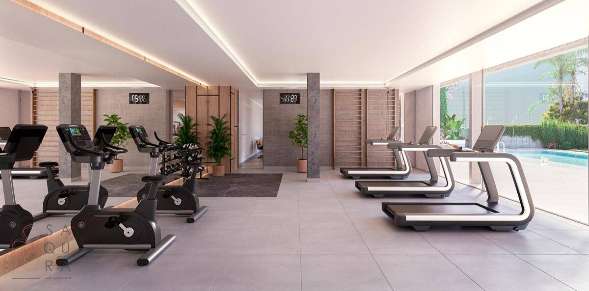Gut ausgestatteter Fitnessraum mit Laufbändern, Fahrrädern und Blick auf den Poolbereich.