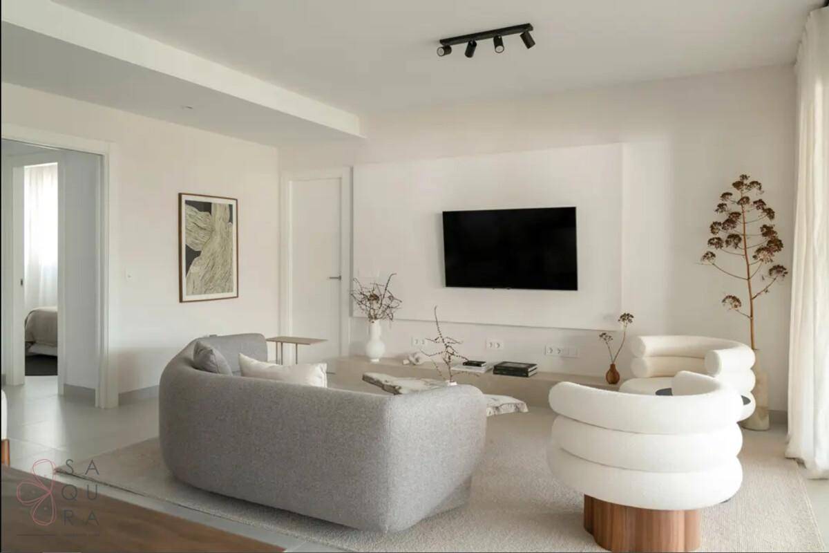 Modern eingerichtetes Wohnzimmer mit bequemen Sofas und minimalistischer Dekoration.