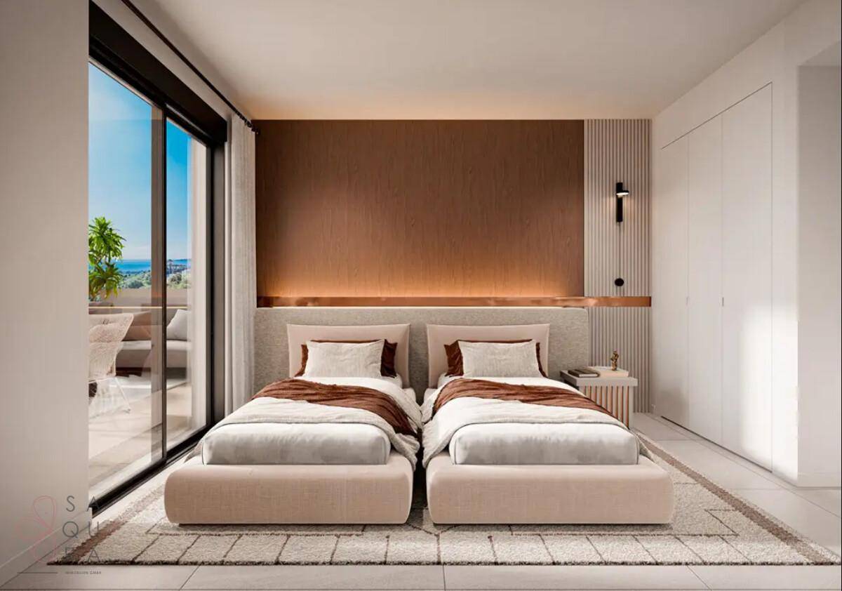 Helles Schlafzimmer mit zwei Einzelbetten, integrierten Schränken und großem Fenster mit Ausblick.