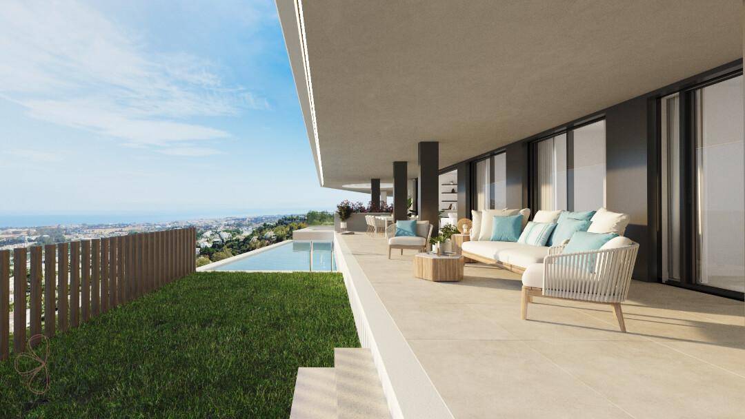Geräumige Terrasse mit privatem Rasenbereich, Pool und atemberaubendem Meerblick unter blauem Himmel.
