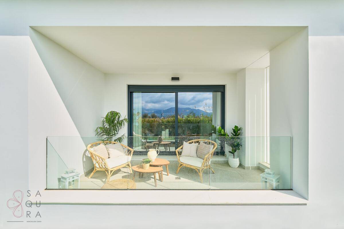 Gemütlicher Balkon mit Sitzgelegenheiten und weitem Blick auf die Berge und Landschaft.