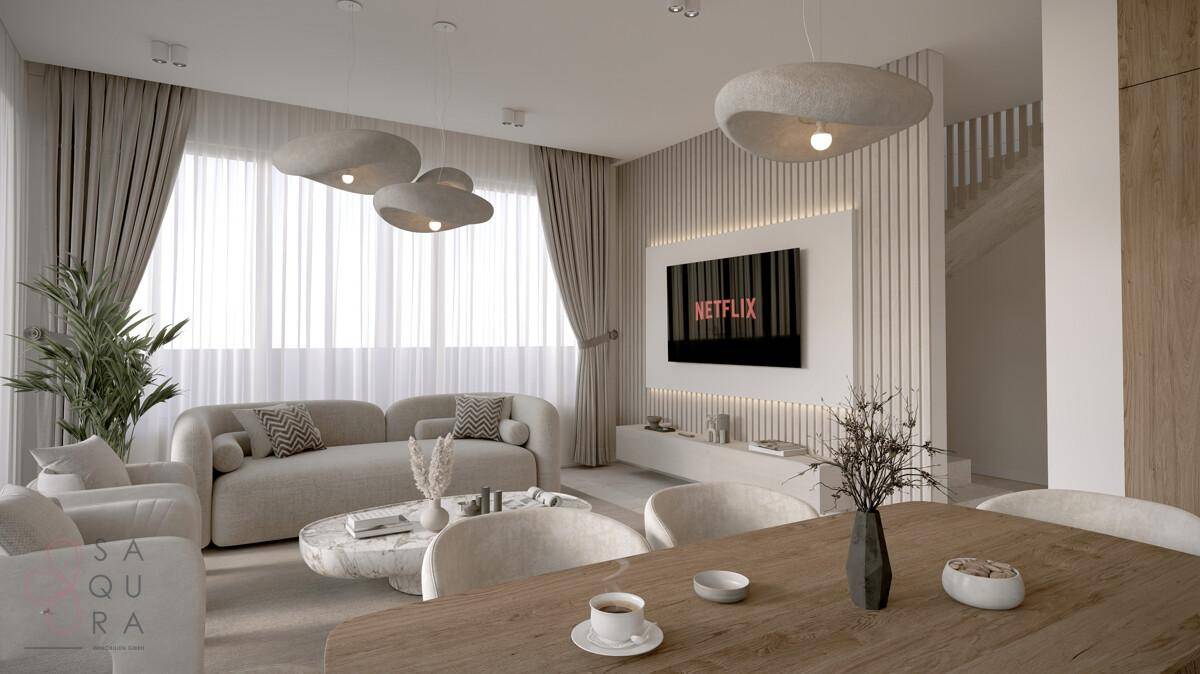 Modernes Wohnzimmer mit bequemen Sofas, stilvollen Pendelleuchten und großem Fenster.