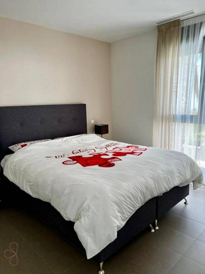Schlafzimmer mit großem Doppelbett und bodentiefen Fenstern für viel Helligkeit.