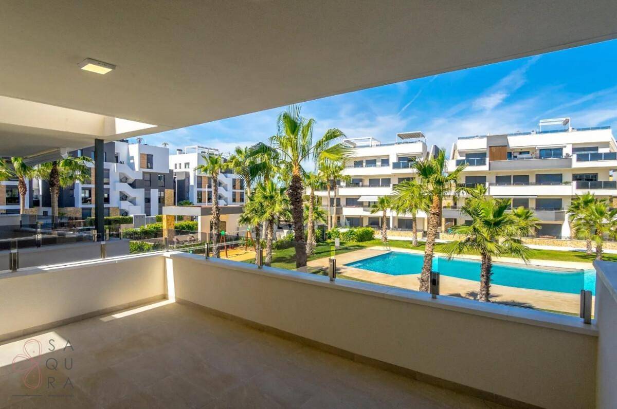 Geräumiger Balkon mit Blick auf die Gemeinschaftsanlage mit Pool und Palmen.