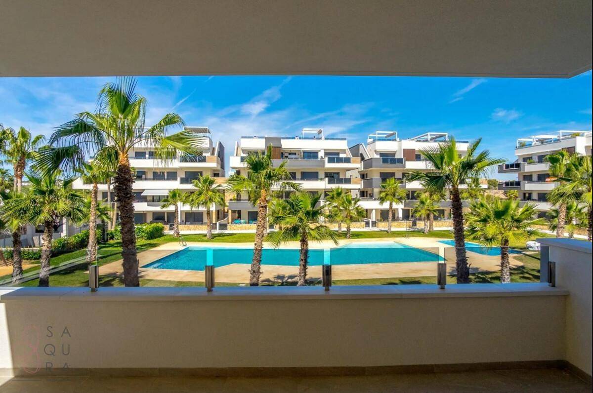 Blick vom Balkon auf die Poolanlage und die modernen Gebäude des Wohnkomplexes.