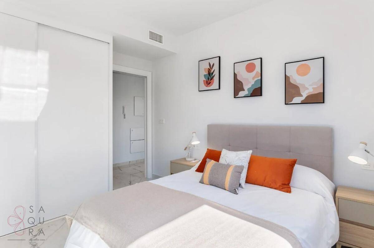 Modern eingerichtetes Schlafzimmer mit Doppelbett, Nachttischen und farbigen Kissen.