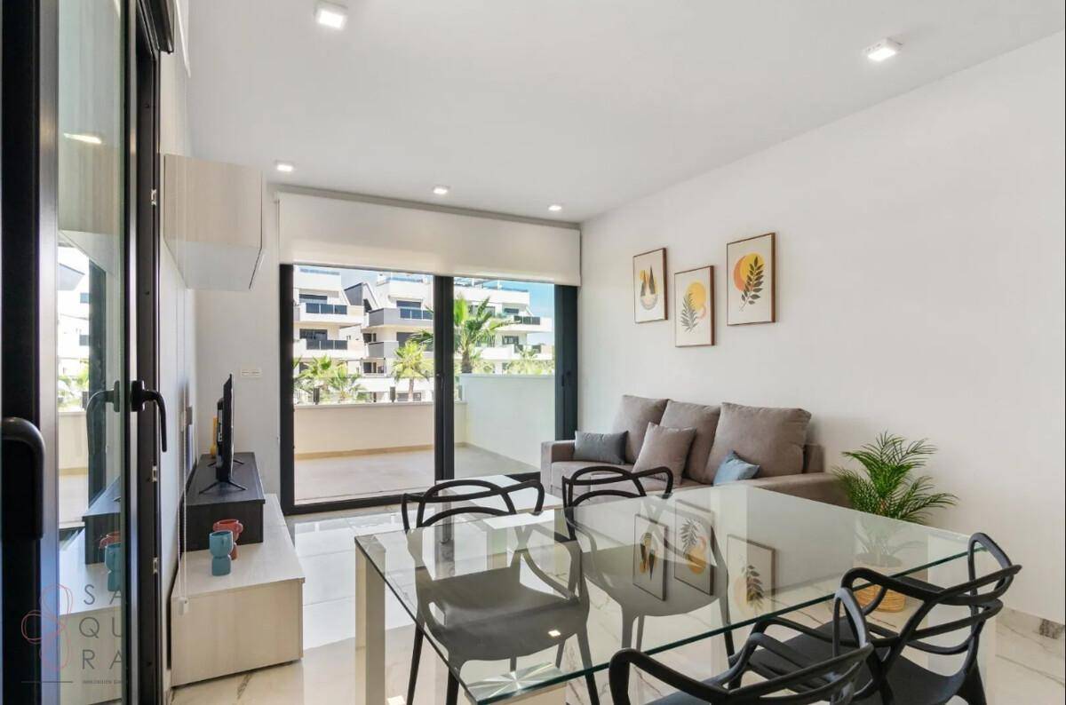 Heller Wohn-Essbereich mit großem Fenster und Zugang zum Balkon, modern eingerichtet.