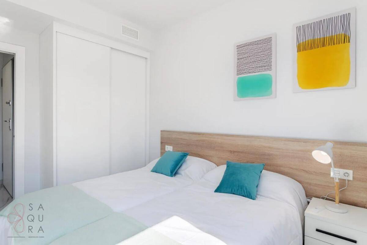 Gemütliches Schlafzimmer mit zwei Einzelbetten, Einbauschrank und moderner Wanddekoration.