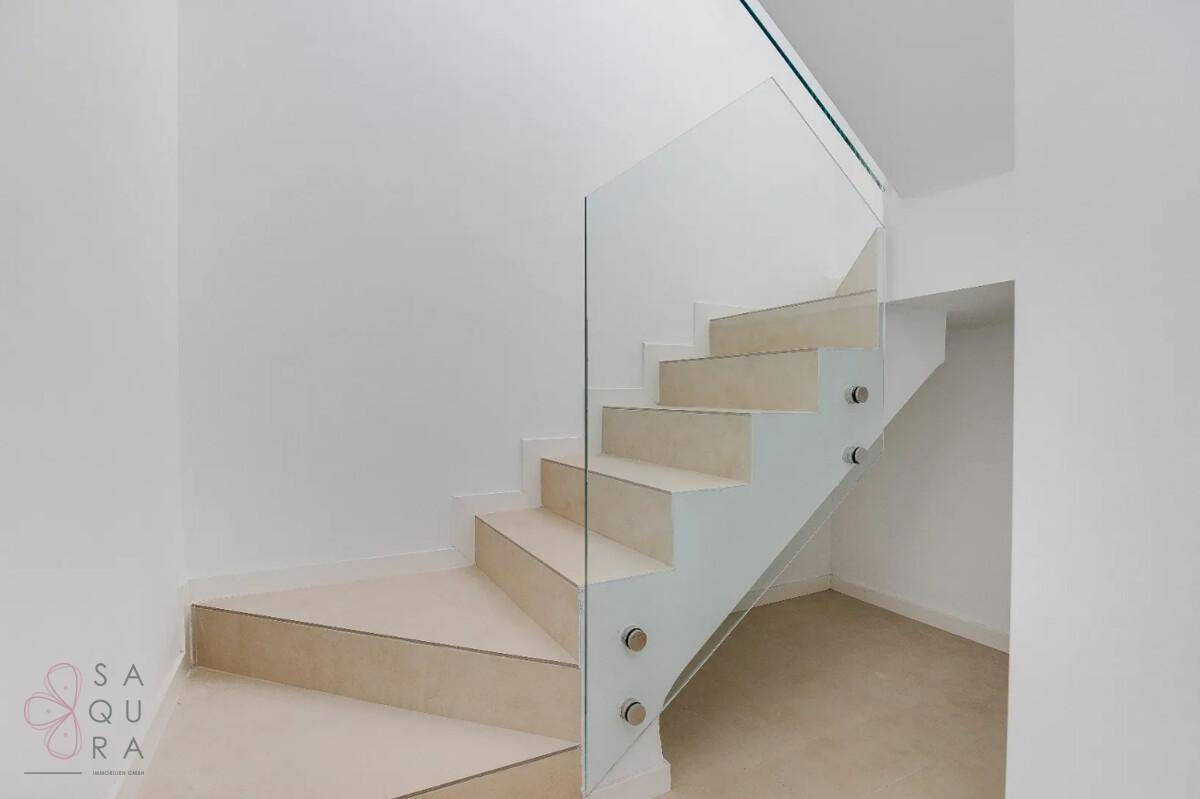 Elegante Treppe mit minimalistischem Design und Glasgeländer, das für Offenheit sorgt.