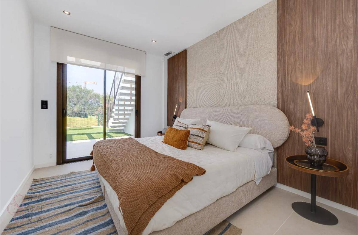 Modernes Schlafzimmer mit großem Bett, Holzakzenten und direktem Zugang zum Außenbereich.