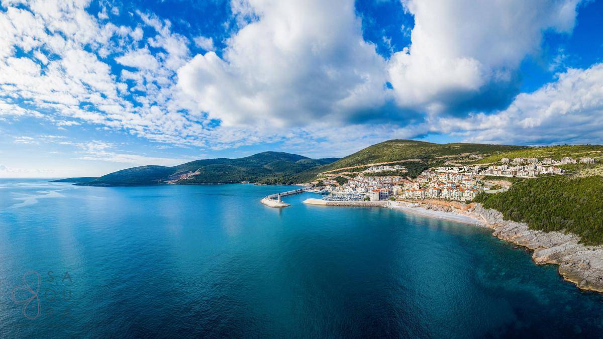 Panorama-Luftaufnahme der malerischen Küste mit Bergen und dem tiefblauen Meer.