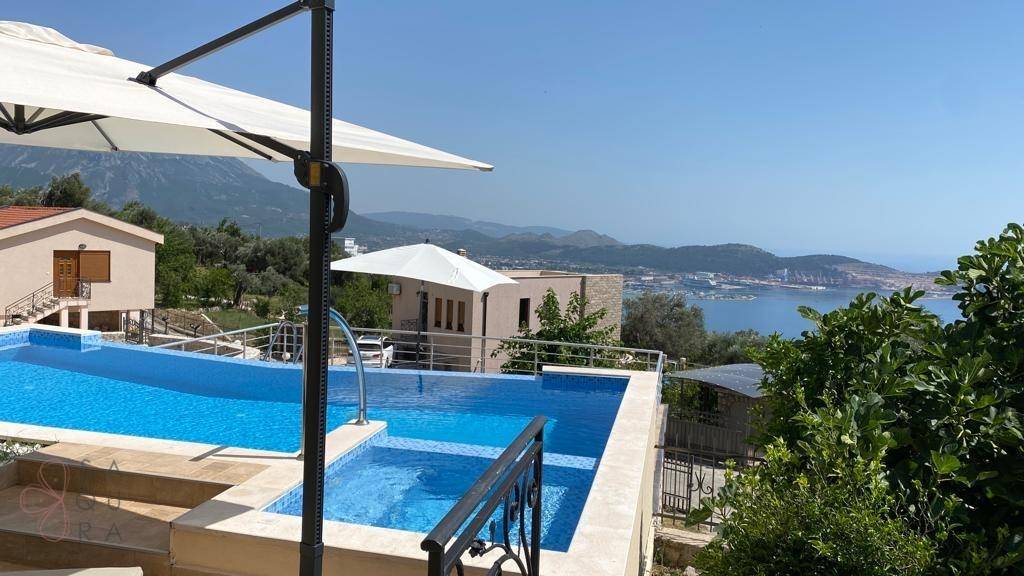 Poolbereich mit weitem Blick auf das Meer, die Berge und die umliegende Küstenlandschaft.