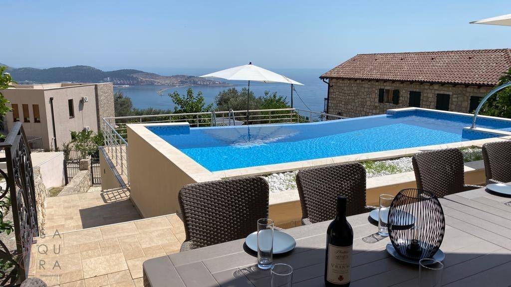 Geräumige Terrasse mit Esstisch, Pool und herrlichem Panoramablick auf das Meer.