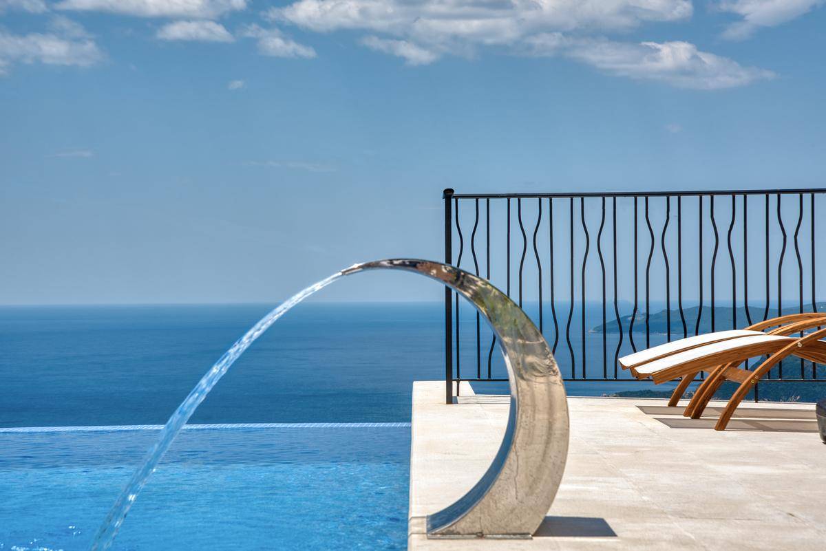 Detailansicht des Infinity-Pools mit elegantem Wasserspiel und unverbautem Blick auf das offene Meer.