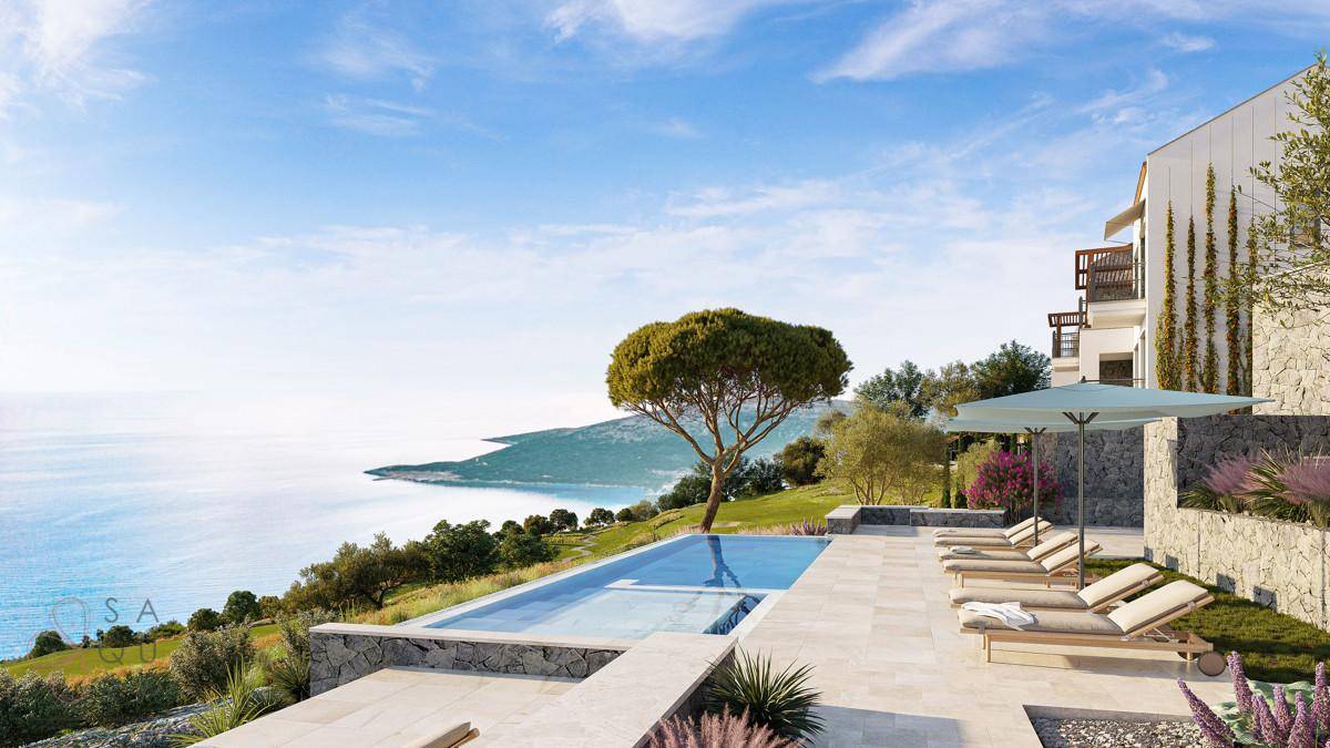 Infinity-Pool mit Liegestühlen und weitem Meerblick vor einer modernen Villa.