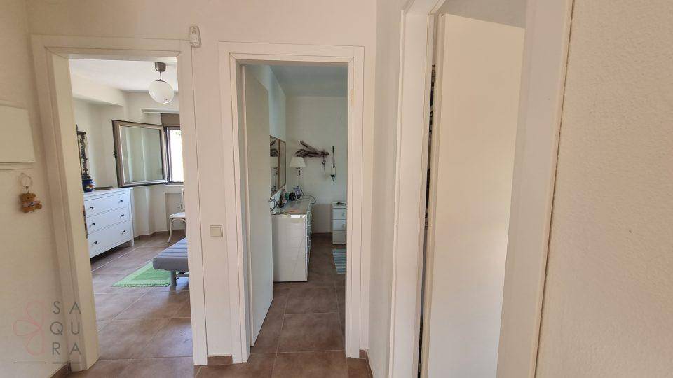 Heller Flur mit Fliesenboden, der zu einem Schlafzimmer und einem Badezimmer führt.