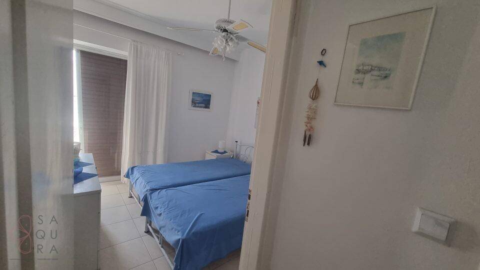 Helles Schlafzimmer mit zwei Einzelbetten, Fliesenboden und Deckenventilator.