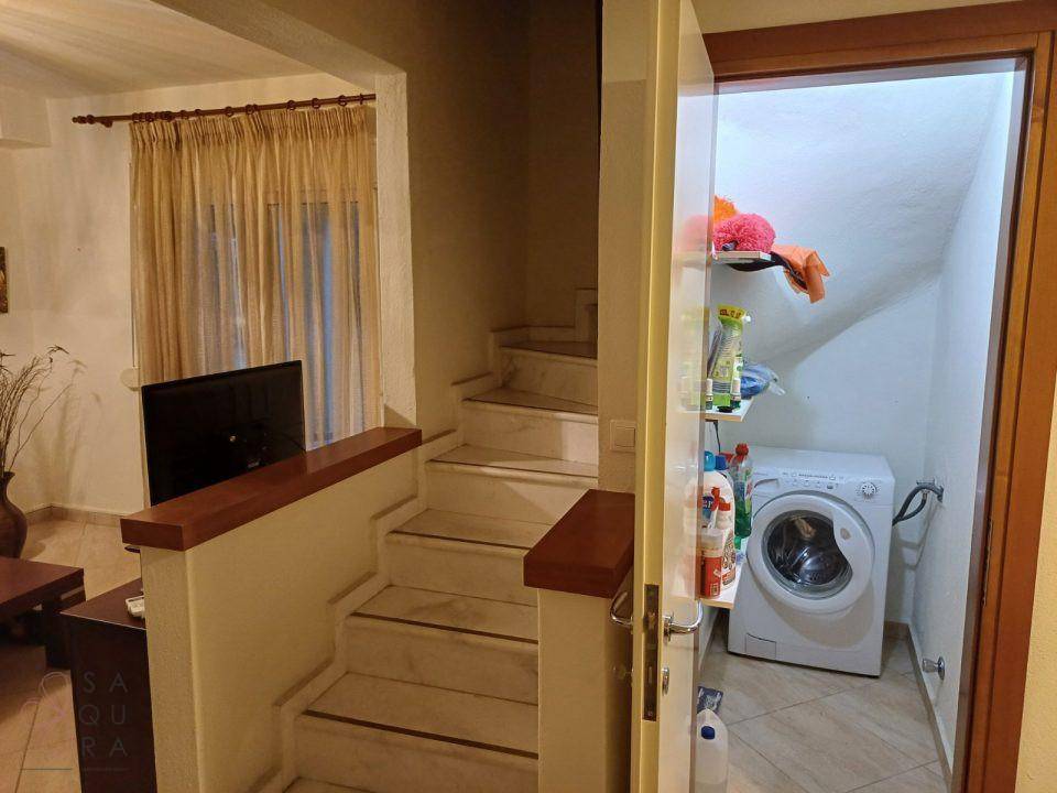 Marmortreppe führt in die obere Etage, daneben ein praktischer Abstellraum mit Regalen.