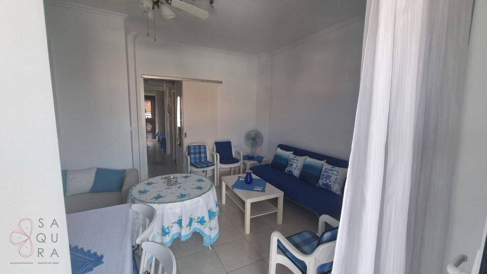 Gemütlicher Wohn-Essbereich mit blauen Akzenten, Deckenventilator und Blick auf den Flur.