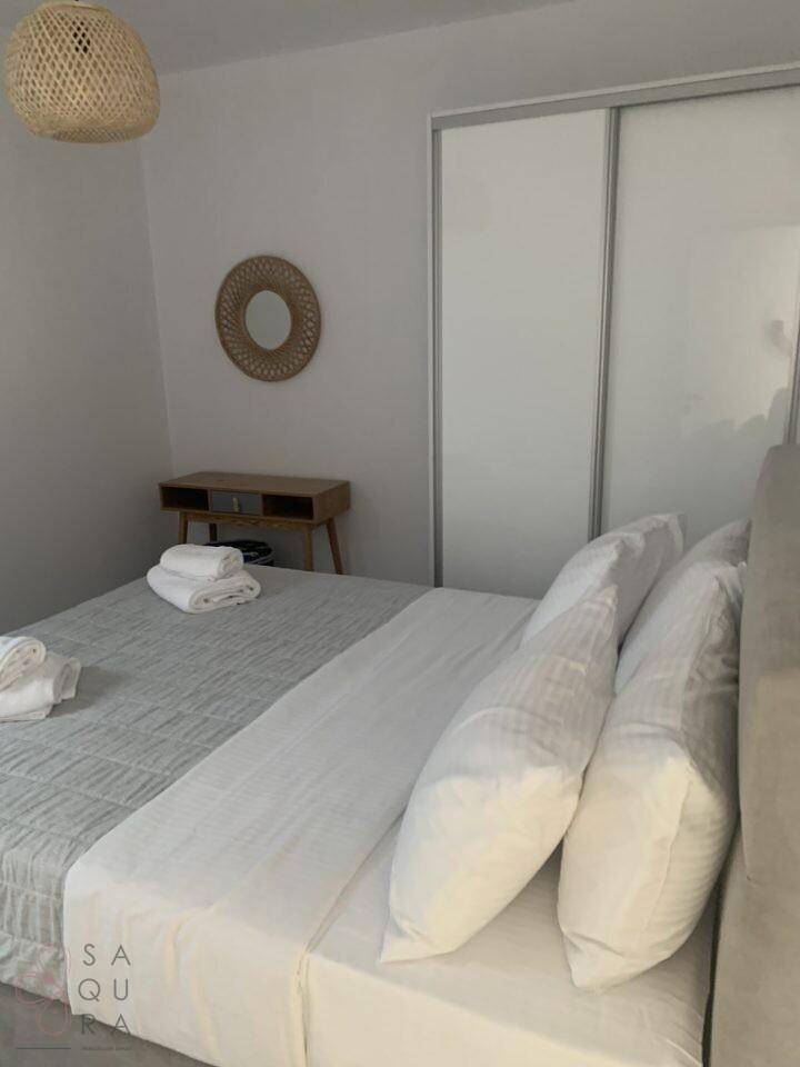 Schlafzimmer mit Doppelbett und einem integrierten, weißen Schiebetürenschrank.