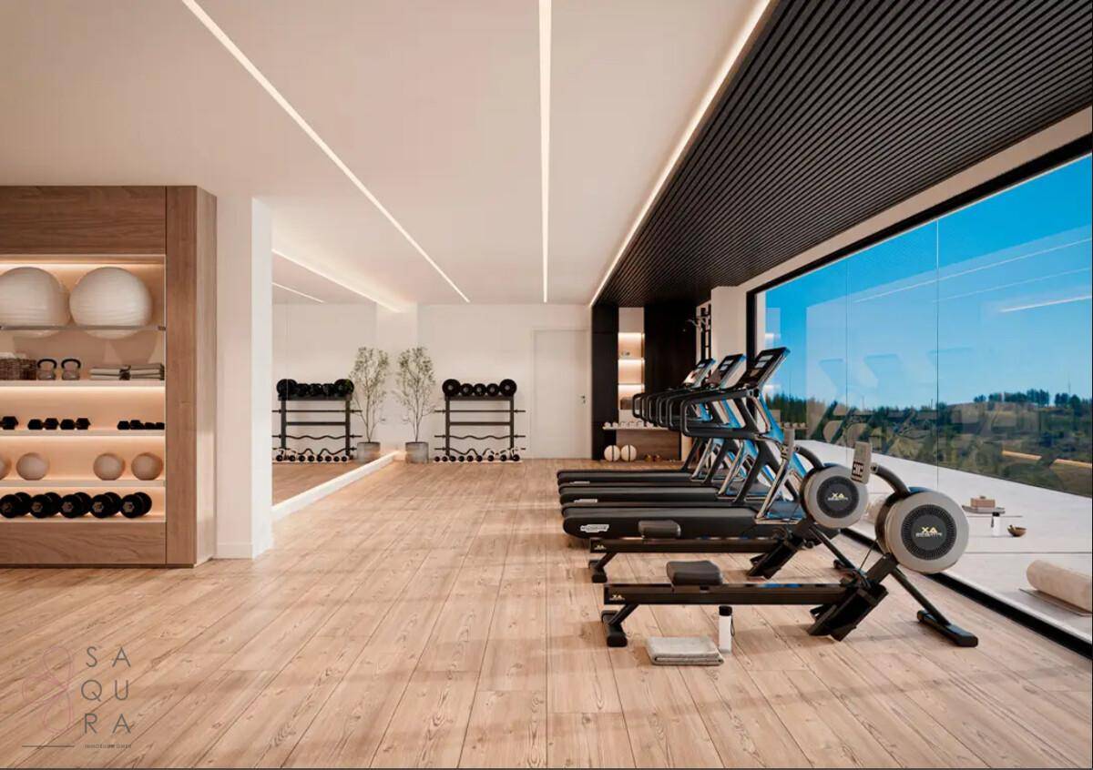 Moderner Fitnessraum mit Laufbändern, Gewichten und großen Fenstern mit Ausblick.