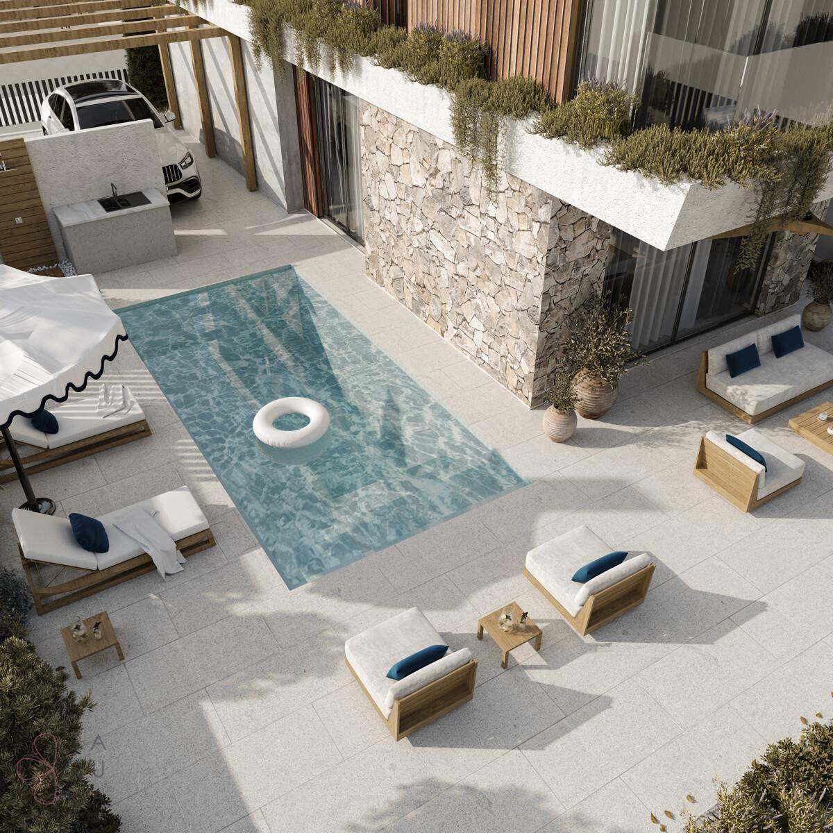 Luftaufnahme der großzügigen Poolterrasse mit Sonnenliegen und Außenküche.