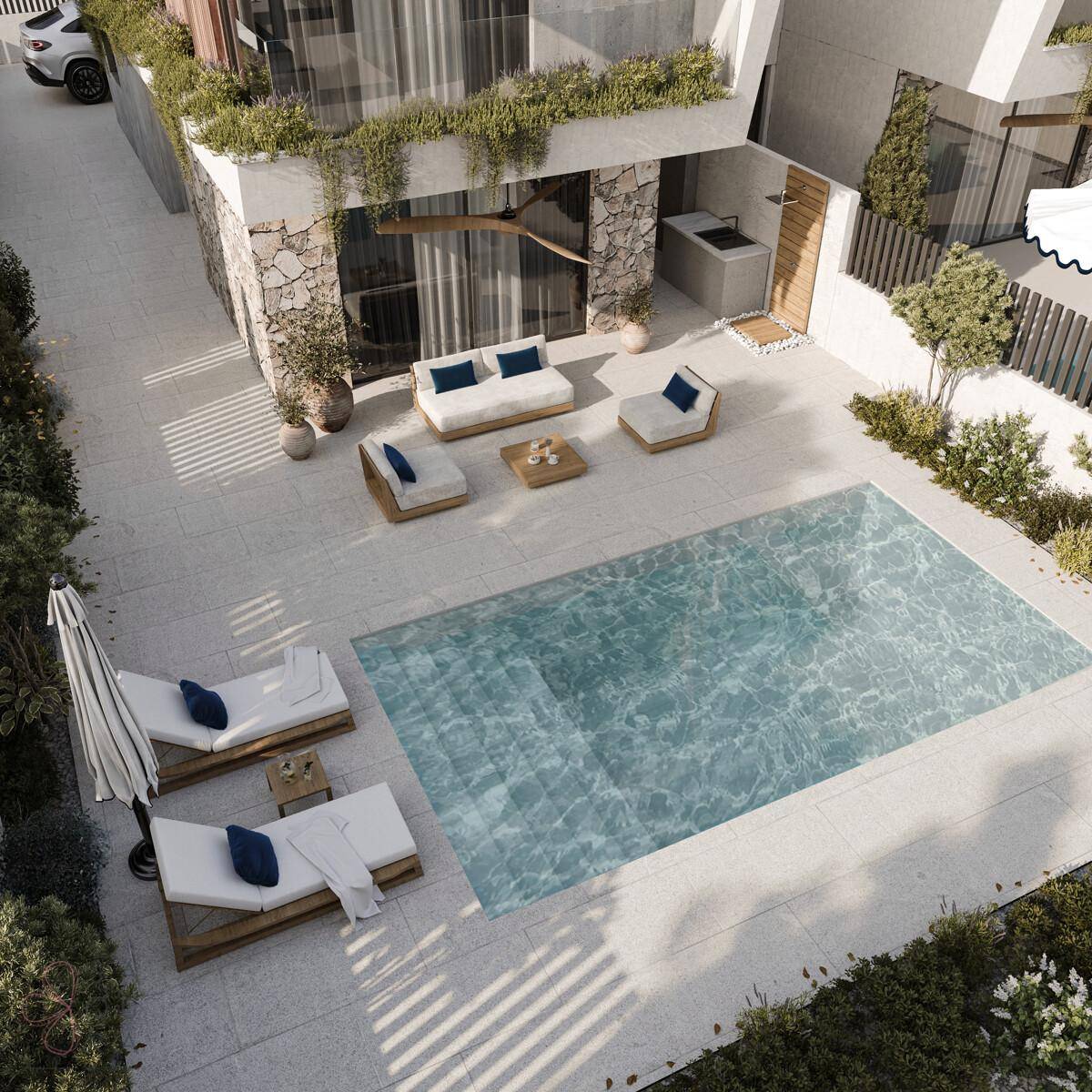 Weitläufige Poolterrasse mit Liegeflächen und Lounge-Möbeln für entspannte Stunden im Freien.