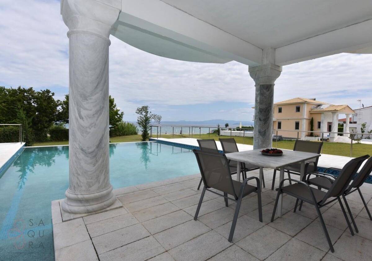 Gemütlicher Essbereich im Freien neben dem Pool mit Panoramablick auf das Meer.