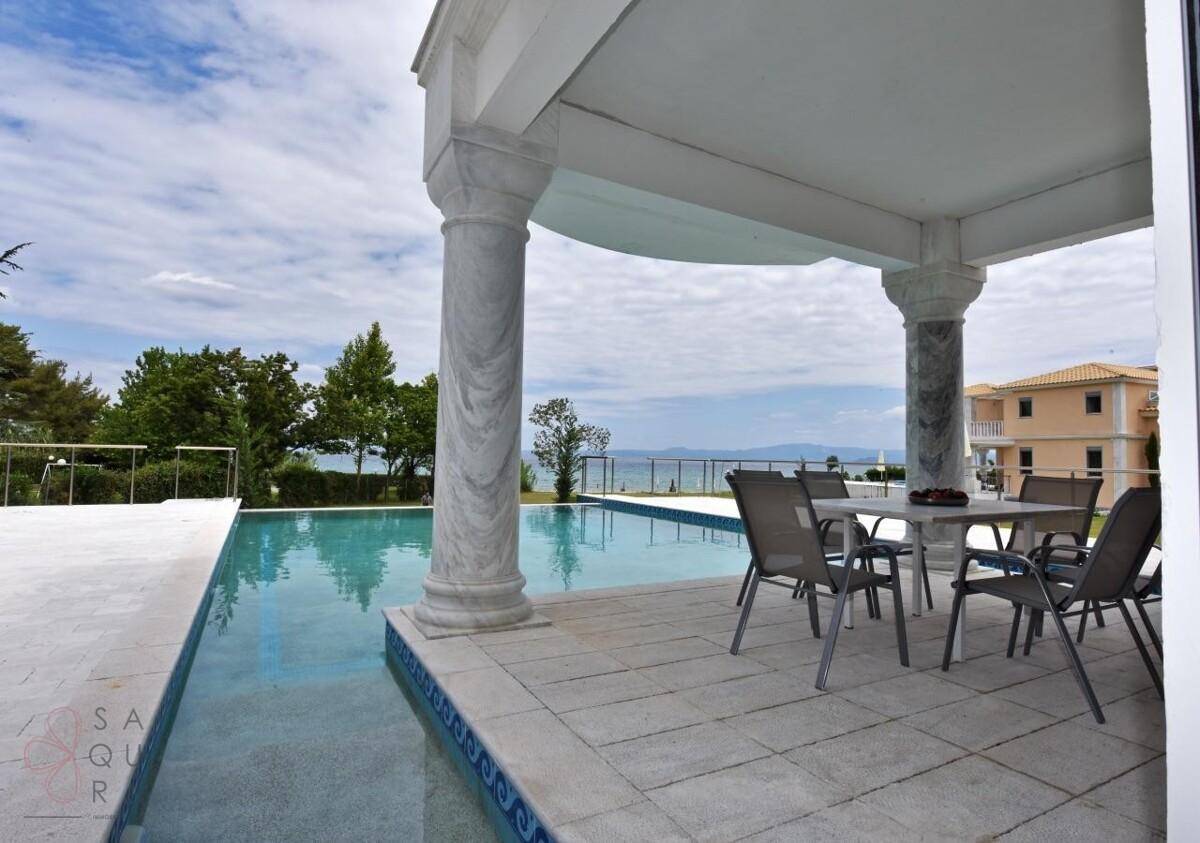 Überdachter Sitzbereich am Pool mit Blick auf das Meer und die umliegende Landschaft.