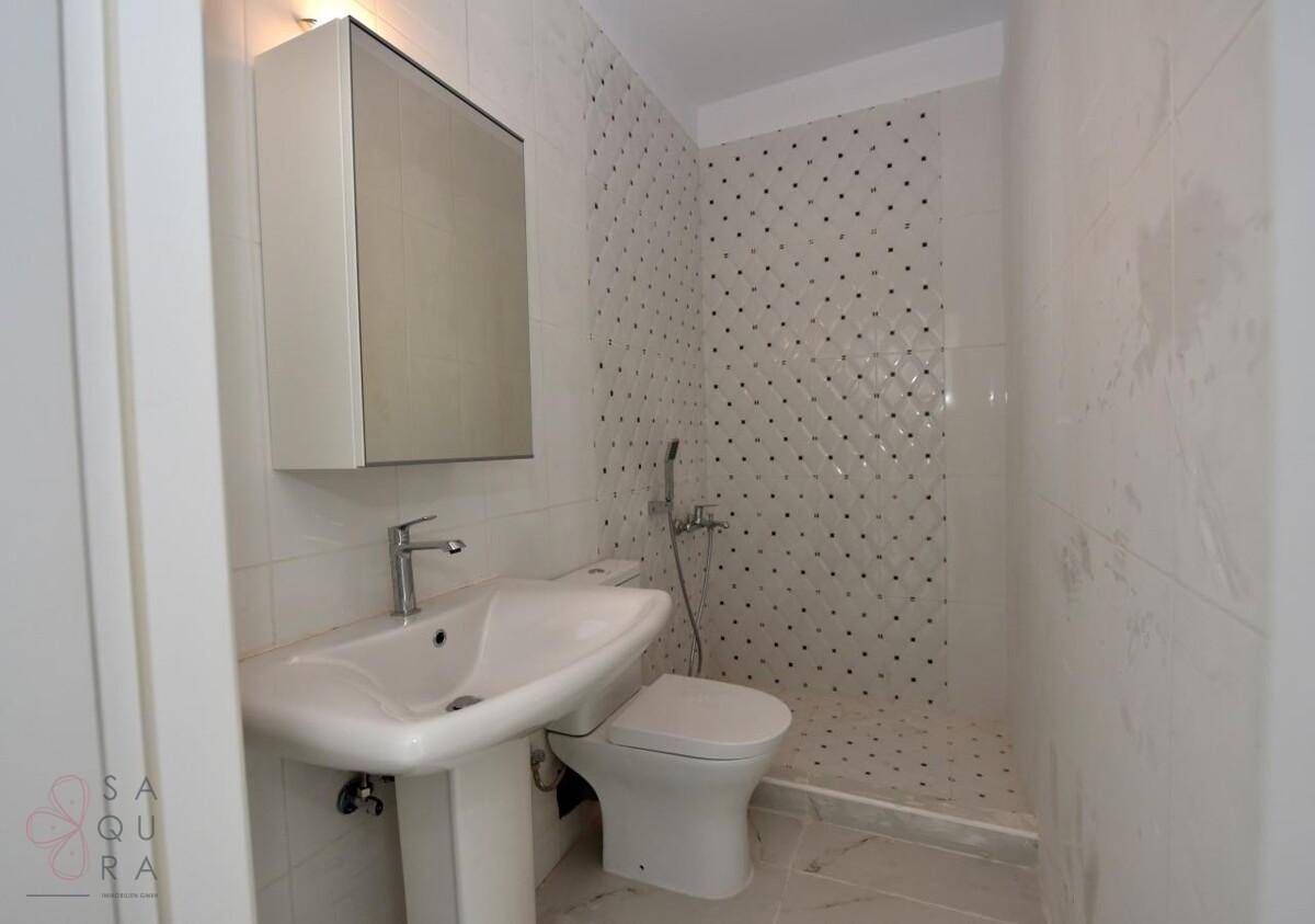 Modernes Badezimmer mit Duschbereich, Waschbecken und Spiegelschrank.