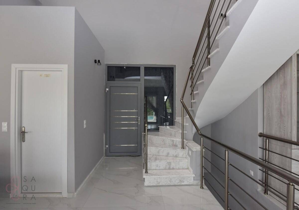 Heller Eingangsbereich mit moderner Tür und Zugang zur Treppe.