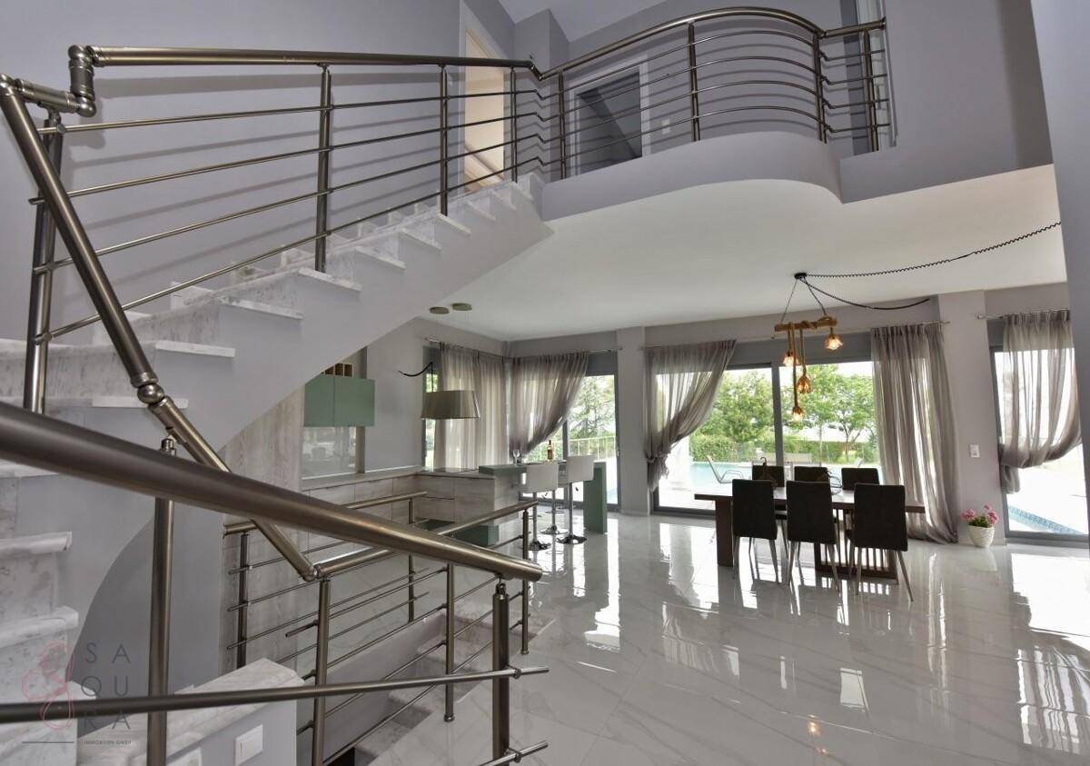 Elegante Treppe mit Edelstahlgeländer, die die verschiedenen Ebenen verbindet.