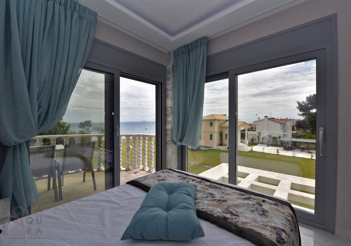 Helles Schlafzimmer mit Meerblick und Zugang zu einem privaten Balkon.