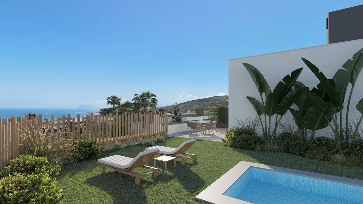 Gartenbereich mit Sonnenliegen, kleinem Pool und weitem Blick auf das Meer und die Küste.