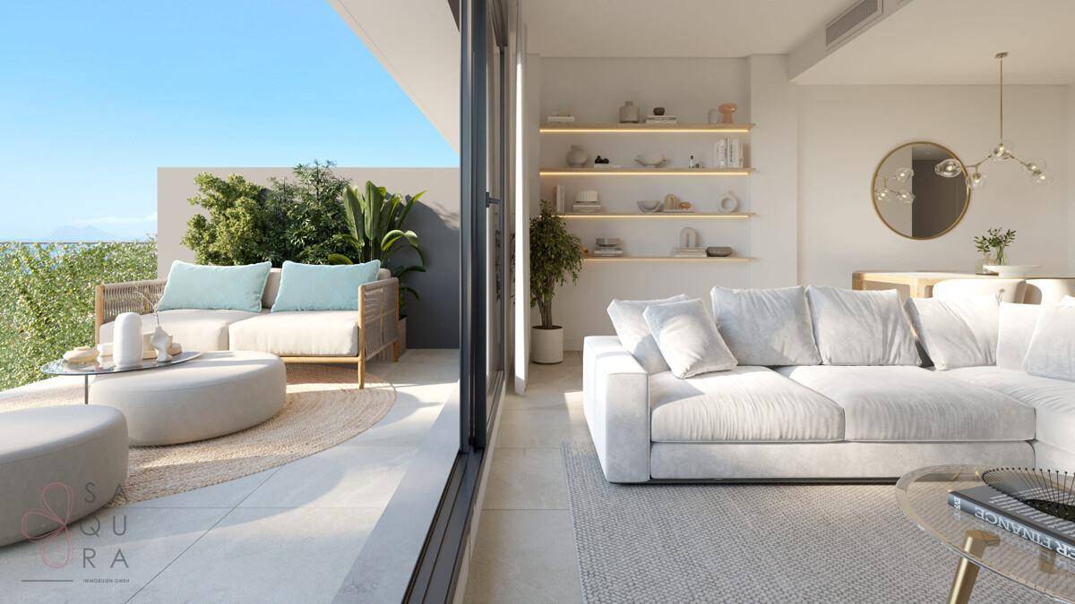 Helles Wohnzimmer mit Zugang zu einer möblierten Terrasse und Blick auf das Meer.