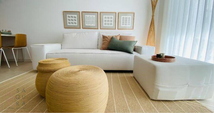 Helles Wohnzimmer mit weißem Sofa, natürlichen Materialien und moderner Dekoration.