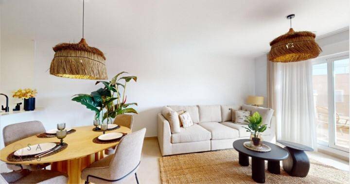 Heller Wohnbereich mit beigem Sofa, Esstisch und Zugang zum Balkon, lichtdurchflutet.